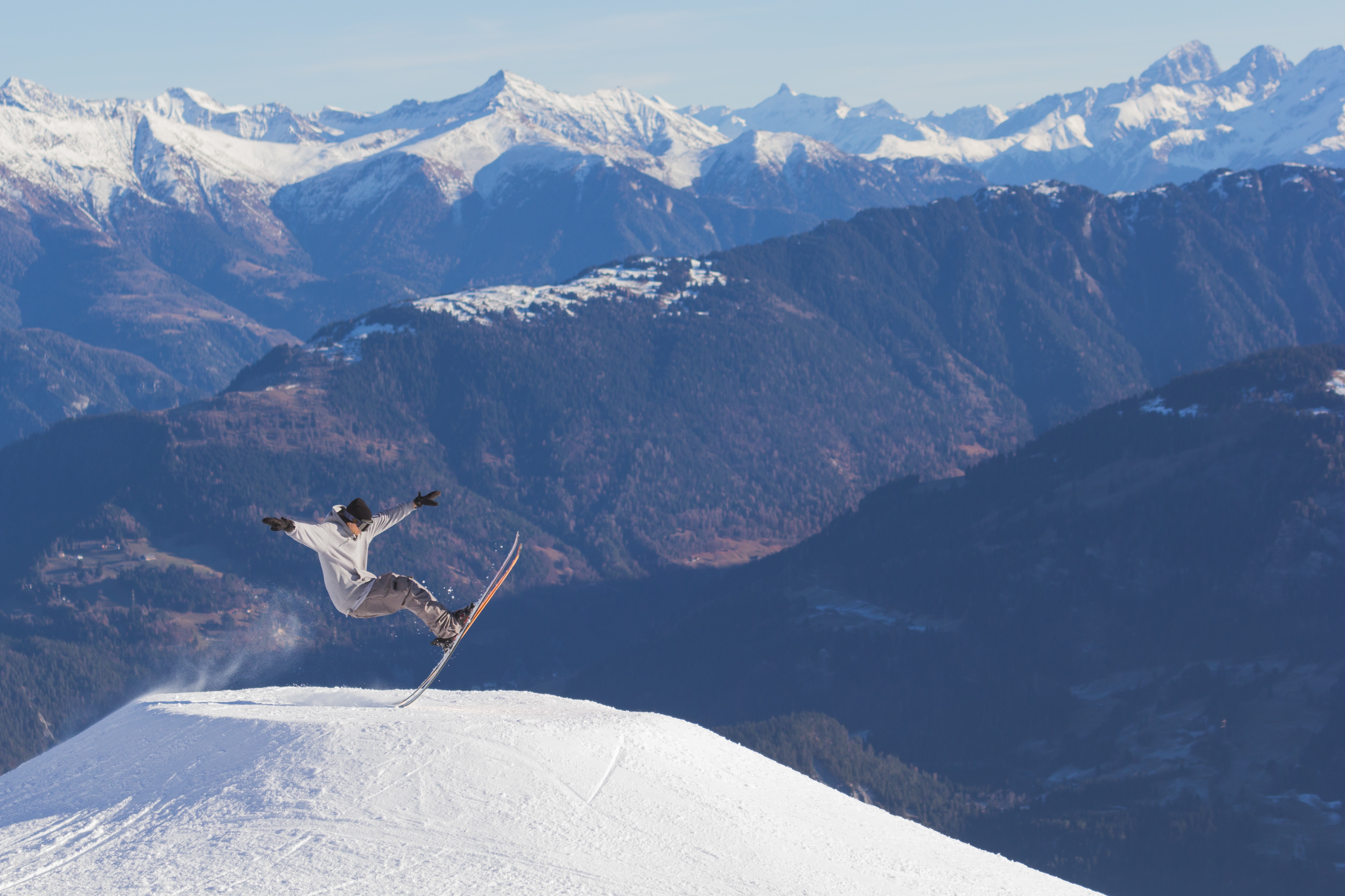 Photo of a man doing ski tricks on top of a snowy mountain